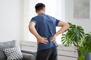 Man holding lower back due to kidney stone symptoms